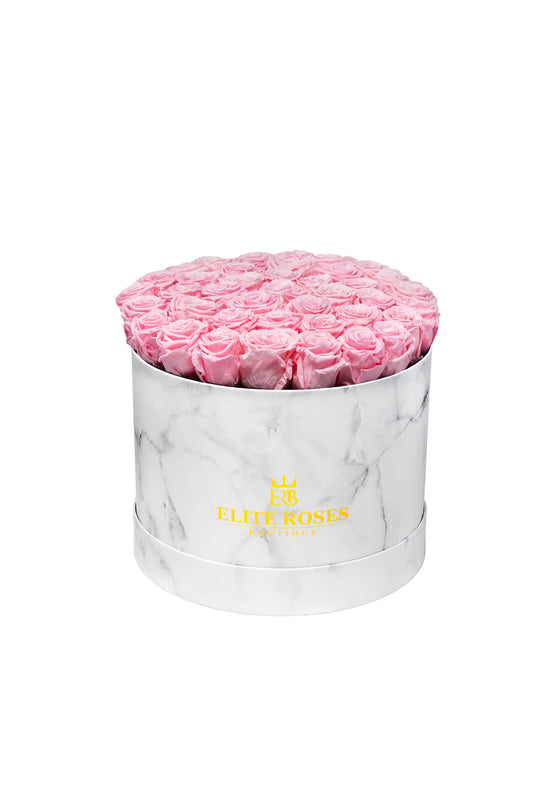 Pink roses in a large round box